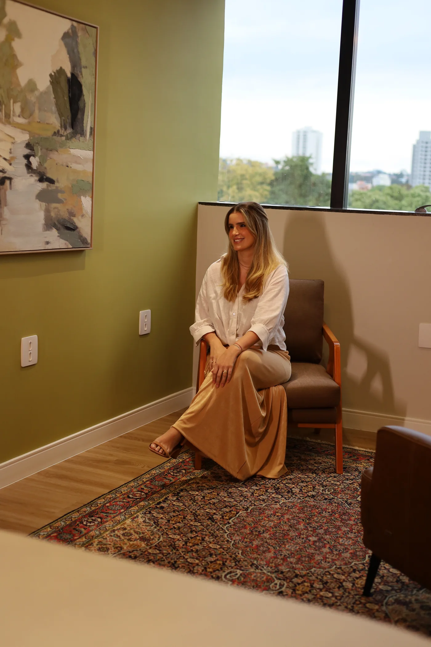 Isabella sentada na poltrona do consultório, sorrindo